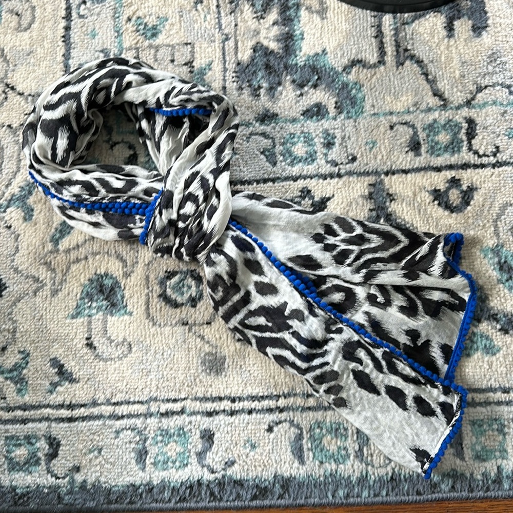 Black and white print knit scarf with blue mini pom pom ball edge detail